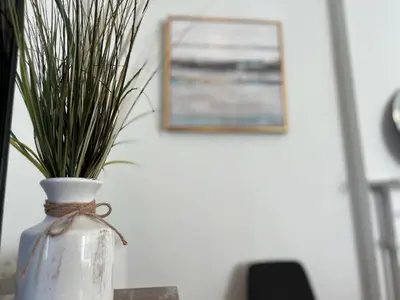 a vase with grass in it sitting on a table at Skyline Retreat Spacious Elegance Queen Suite 4 City Views in Cincinnati