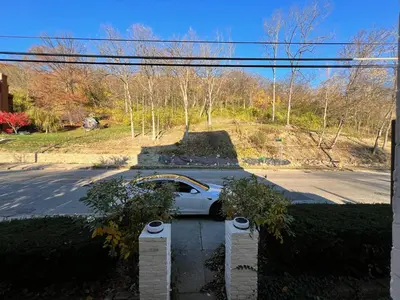 a white car is parked in a driveway at Skyline Retreat Spacious Elegance Queen Suite 4 City Views in Cincinnati