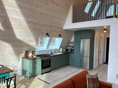 a kitchen with green cabinets and a couch in a room at Fox Ridge-Black Alder Lodging in Logan