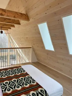 a log cabin with two windows and a bed at Fox Ridge-Black Alder Lodging in Logan