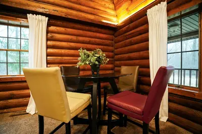 a dining room with a table and chairs and windows at WinklerWald- 6 BR family retreat in Atwater