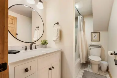 a bathroom with a sink and a toilet and a mirror at WinklerWald- 6 BR family retreat in Atwater