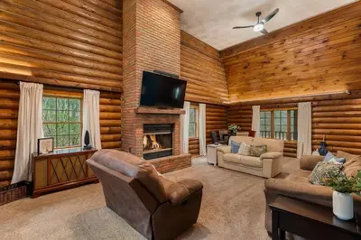 a living room with wooden walls and a fireplace at WinklerWald- 6 BR family retreat in Atwater