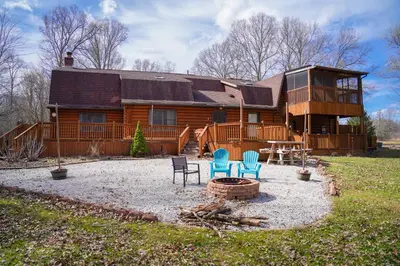 a log cabin with two chairs and a fire pit at WinklerWald- 6 BR family retreat in Atwater