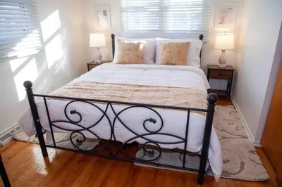 a bedroom with a large bed with white sheets and pillows at Cozy 3 Bedroom Home in Reynoldsburg