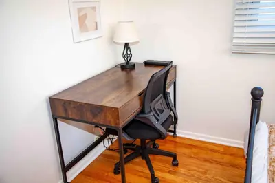 a desk with a chair and a lamp on it at Cozy 3 Bedroom Home in Reynoldsburg