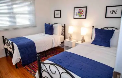 two beds in a bedroom with blue and white at Cozy 3 Bedroom Home in Reynoldsburg