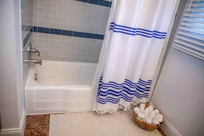 a bathroom with a tub and a shower curtain at Cozy 3 Bedroom Home in Reynoldsburg