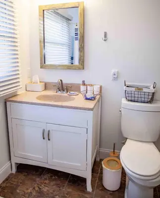 a bathroom with a sink and a toilet with a mirror at Cozy 3 Bedroom Home in Reynoldsburg