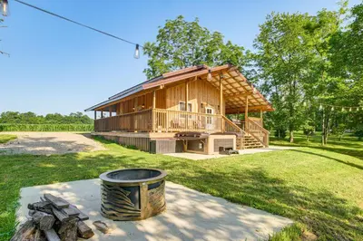 a large wooden house with a grill in a yard at Friends and Family Rental Cabin with Hot Tub! in Somerset
