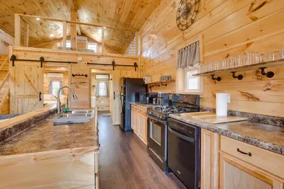 a large kitchen with wooden walls and wooden counters at Friends and Family Rental Cabin with Hot Tub! in Somerset