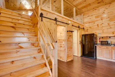 a log cabin with a staircase in a kitchen at Friends and Family Rental Cabin with Hot Tub! in Somerset