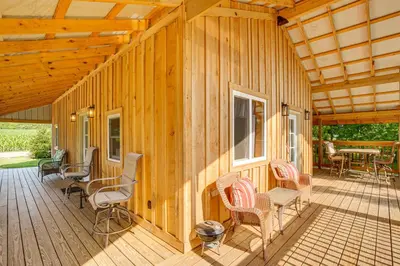 a porch of a wooden house with chairs and a table at Friends and Family Rental Cabin with Hot Tub! in Somerset