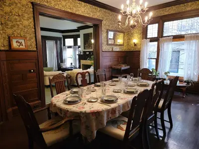 a dining room with a table with chairs and a chandelier at The Kings Throne Inn and Guest House in Toledo