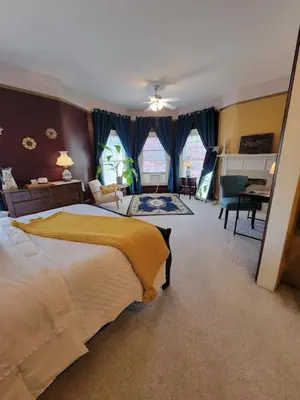 a bedroom with a large bed and a desk at The Kings Throne Inn and Guest House in Toledo