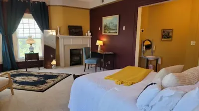 a bedroom with a large bed and a fireplace at The Kings Throne Inn and Guest House in Toledo