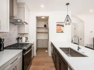 a white kitchen with a sink and a stove at Modern Luxury 4BR 3 5BA Oasis in Historic Old Town East PD in Columbus