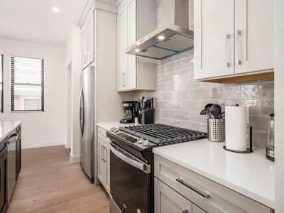 a kitchen with white cabinets and a stove top oven at Modern Luxury 4BR 3 5BA Oasis in Historic Old Town East PD in Columbus