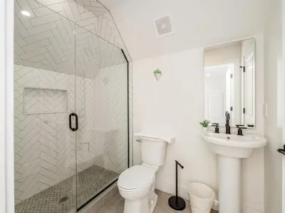 a bathroom with a shower and a toilet and a sink at Modern Luxury 4BR 3 5BA Oasis in Historic Old Town East PD in Columbus
