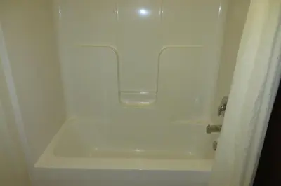 a bathroom with a white bath tub with a sink at Hawthorn Extended Stay by Wyndham Seville in Seville