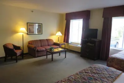 a hotel room with a couch and a tv at Hawthorn Extended Stay by Wyndham Seville in Seville