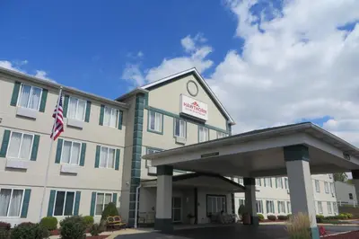 a front view of a hotel with an american flag at Hawthorn Extended Stay by Wyndham Seville in Seville