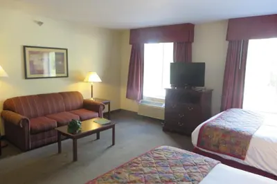 a hotel room with a bed and a couch and a tv at Hawthorn Extended Stay by Wyndham Seville in Seville