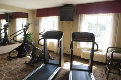 a gym with two exercise bikes and a television at Hawthorn Extended Stay by Wyndham Seville in Seville