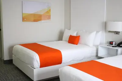 two beds in a hotel room with orange and white at Schoenbrunn Inn in New Philadelphia