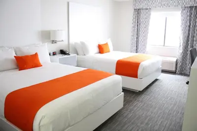 two beds in a hotel room with orange and white at Schoenbrunn Inn in New Philadelphia