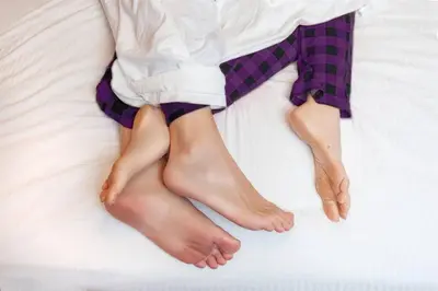 a person laying on a bed with their legs crossed at Refreshing Mid Mod Retreat BG in Bowling Green