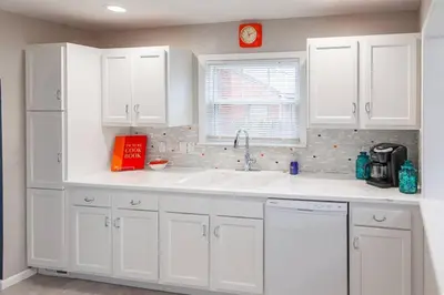 a kitchen with white cabinets and a sink at Refreshing Mid Mod Retreat BG in Bowling Green