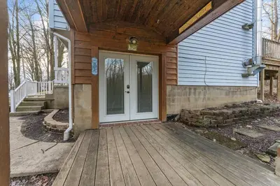 a house with a wooden porch with a white door at Come indulge and escape away! in Salem