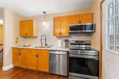 a kitchen with wooden cabinets and a stainless steel appliance at Come indulge and escape away! in Salem