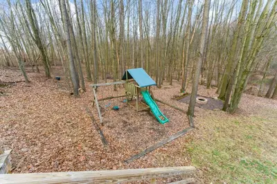 a playground with a green slide in the woods at Come indulge and escape away! in Salem