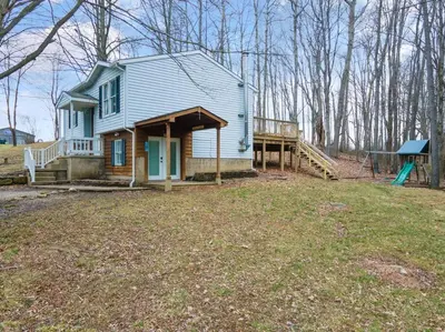 a small blue house with a porch and a deck at Come indulge and escape away! in Salem