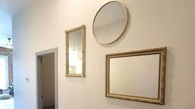 two mirrors on a wall next to a mirror at Private Boutique Getaway - Fireplace & Soaking Tub - Downtown Loft - by Cross-Key Vacation Rentals in Millersburg