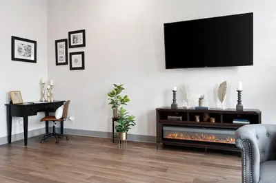 a living room with a fireplace and a television on a wall at Private Boutique Getaway - Fireplace & Soaking Tub - Downtown Loft - by Cross-Key Vacation Rentals in Millersburg