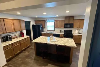 a large kitchen with wooden cabinets and a large island at 3 Bedroom in Hocking Hills w King Bed Logan Ohio in Logan
