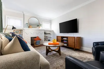 a living room with a couch and a tv at Modern 3BR Near Cleveland Clinic in Cleveland Heights