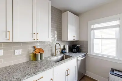 a kitchen with white cabinets and a sink at Modern 3BR Near Cleveland Clinic in Cleveland Heights