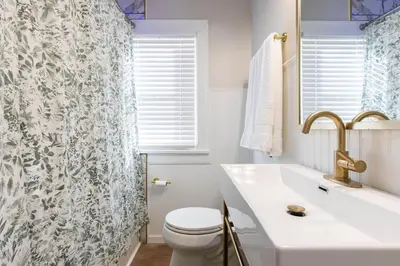 a bathroom with a sink and a toilet and a shower curtain at Modern 3BR Near Cleveland Clinic in Cleveland Heights