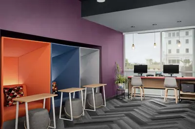 a room with purple walls and tables and chairs at Tru By Hilton Columbus East Broad in Columbus