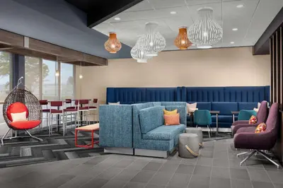 a waiting room with chairs and a table and chairs at Tru By Hilton Columbus East Broad in Columbus