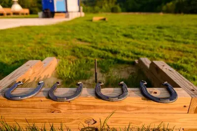a wooden boat with black horseshoes in a field at River Front Hallowed Horse Glamp Tent 2 in Stanton