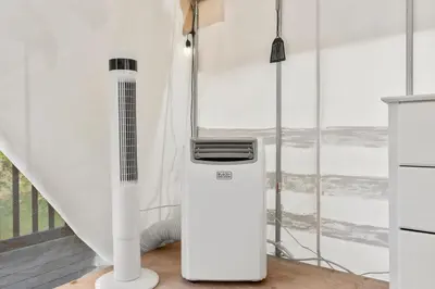 a white heater in a room with a staircase at River Front Hallowed Horse Glamp Tent 2 in Stanton