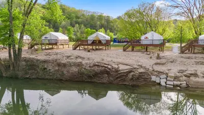 a group of tents next to a body of water at River Front Hallowed Horse Glamp Tent 2 in Stanton