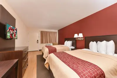 a hotel room with two beds and a flat screen tv at Red Roof Inn Marietta in Marietta