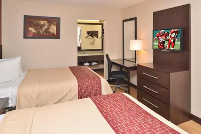 a hotel room with two beds and a desk at Red Roof Inn Marietta in Marietta