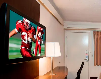 a television with a football player on it in a room at Red Roof Inn Marietta in Marietta